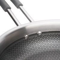 Close-up of a frying pan with a textured surface and metallic handle.