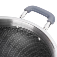 Close-up of a frying pan with a textured bottom and gray handle on a white background
